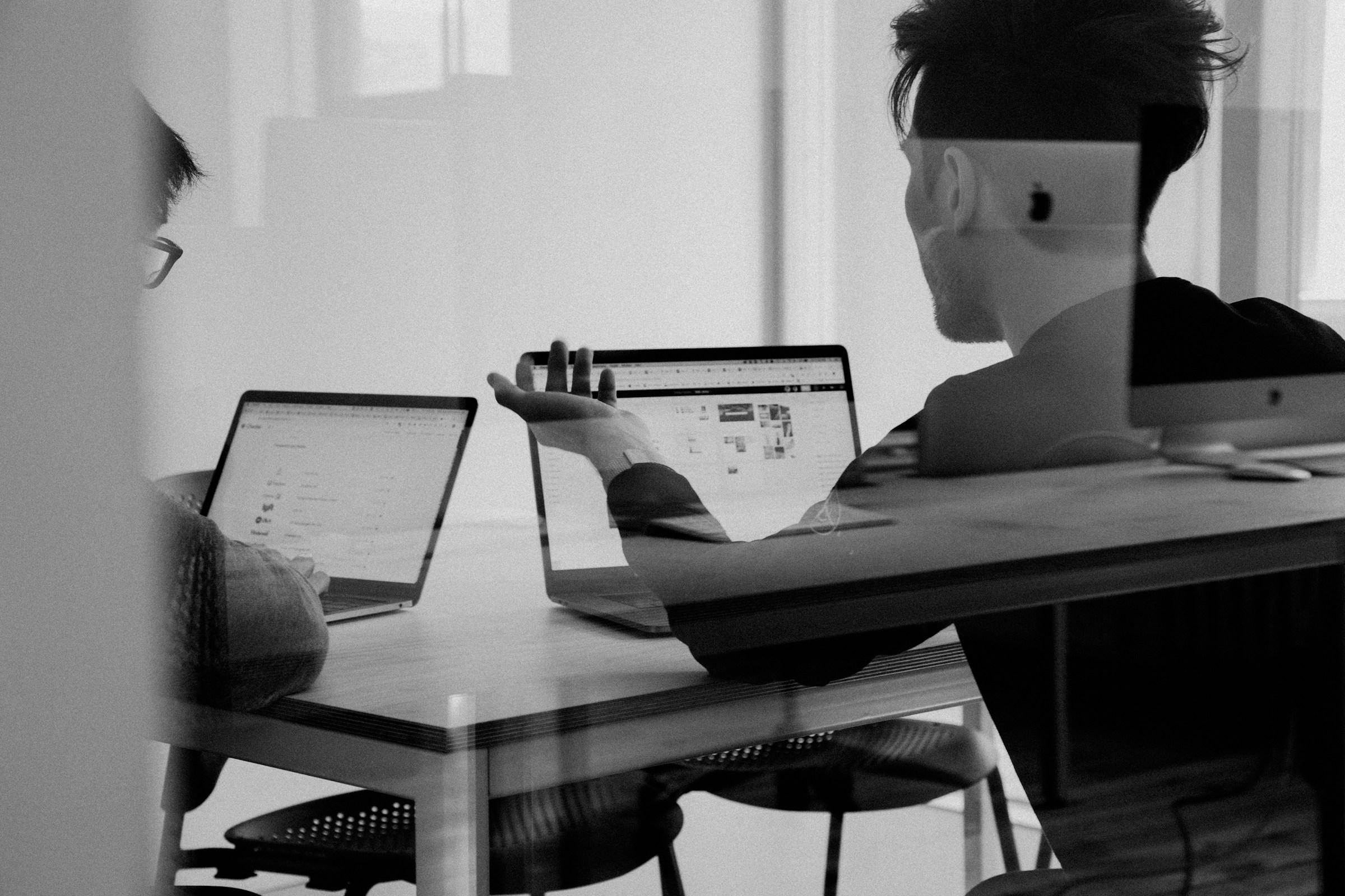 Two professionals shaking hands across a conference table symbolizing sales-marketing alignment